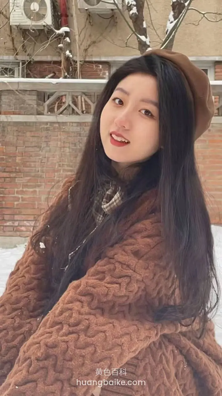 雪地里靠着砖墙，镜头对着脸