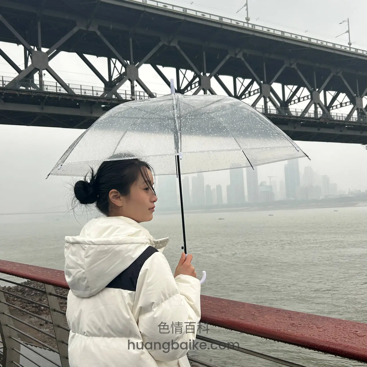 江边大桥下，透明雨伞遮雨看河景