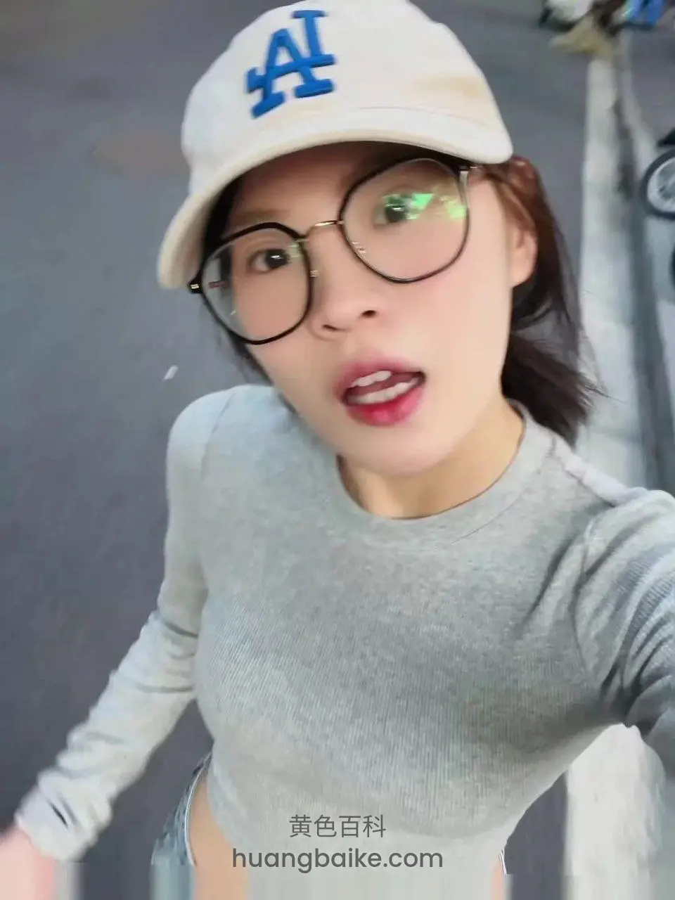 街边戴帽子举着手机自拍