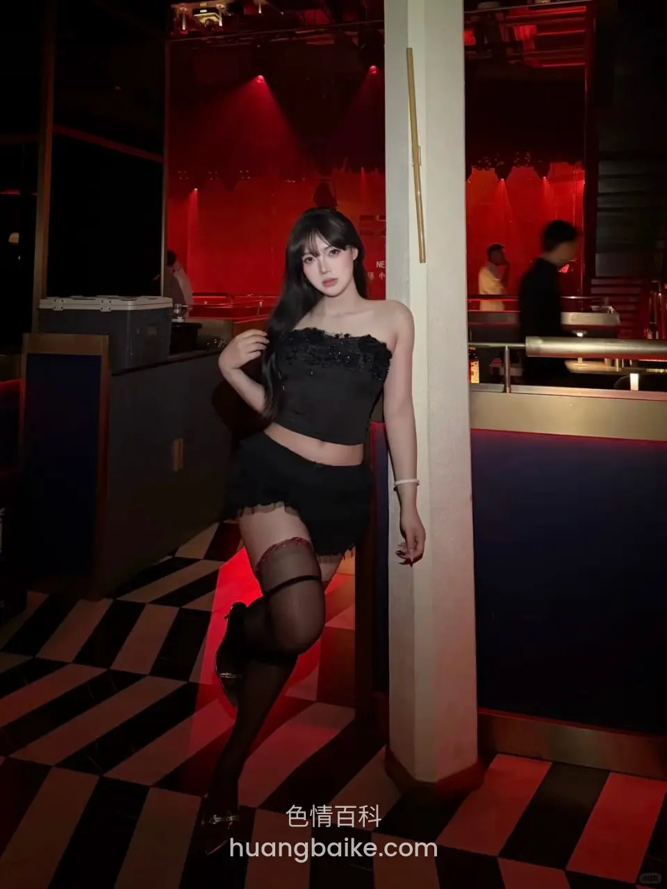红灯柱子旁抬腿靠着，身后是吧台和人影