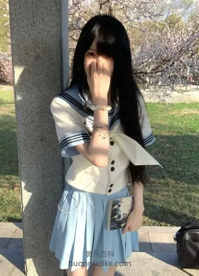 公园柱子旁拿着手机，镜头对着樱花树