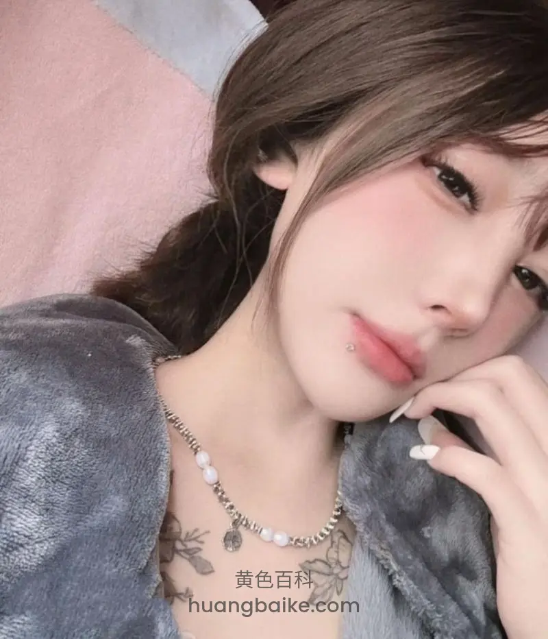 侧躺床上手托下巴，脖子戴项链胸前纹身