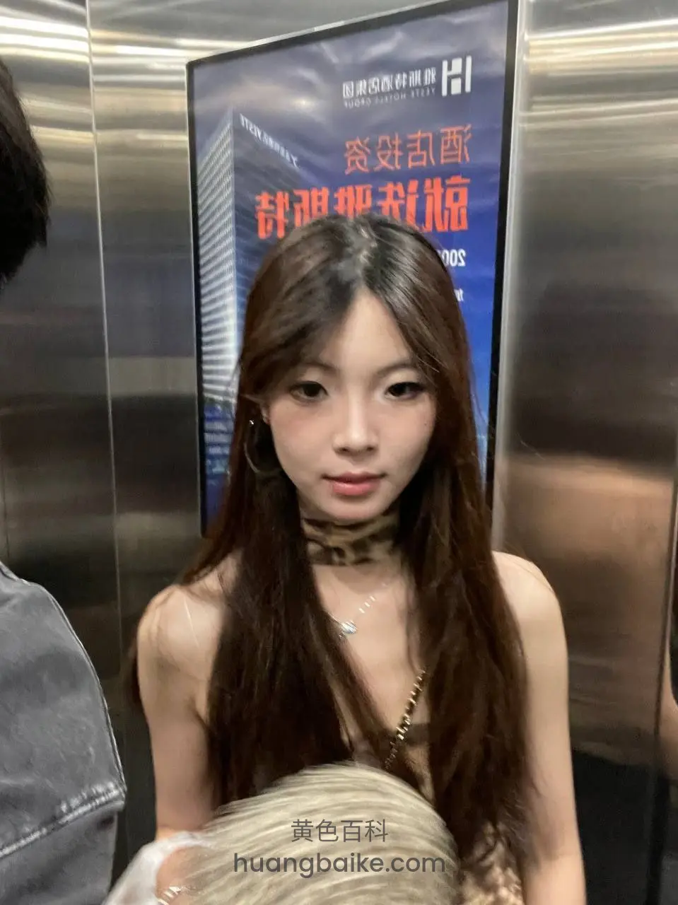 电梯里直视镜头，身前有豹纹包