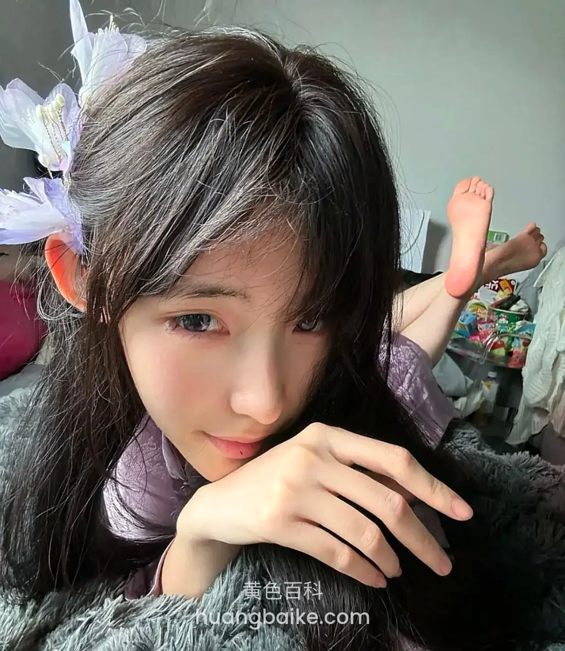 手托下巴看镜头，脚丫举在身后