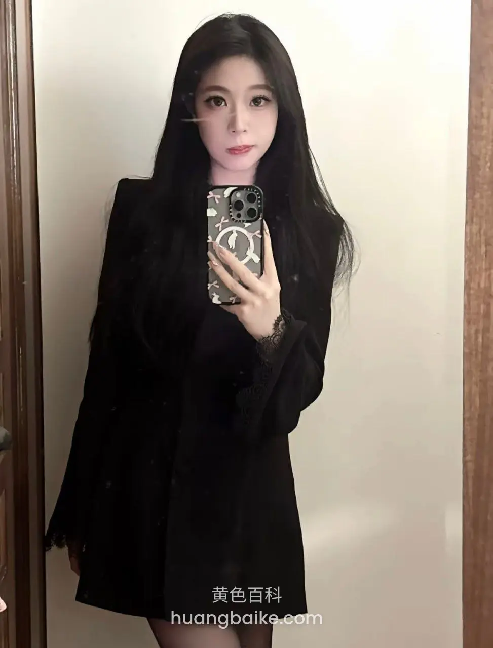 门前举手机自拍，手机壳印着CHANEL