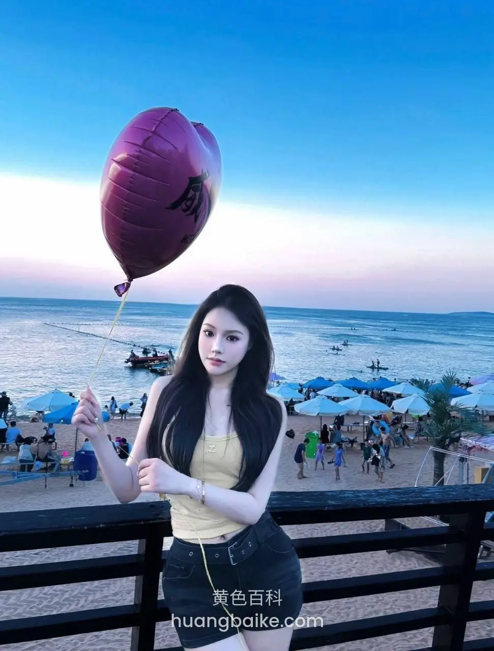 海边栏杆旁拿着紫色心形气球