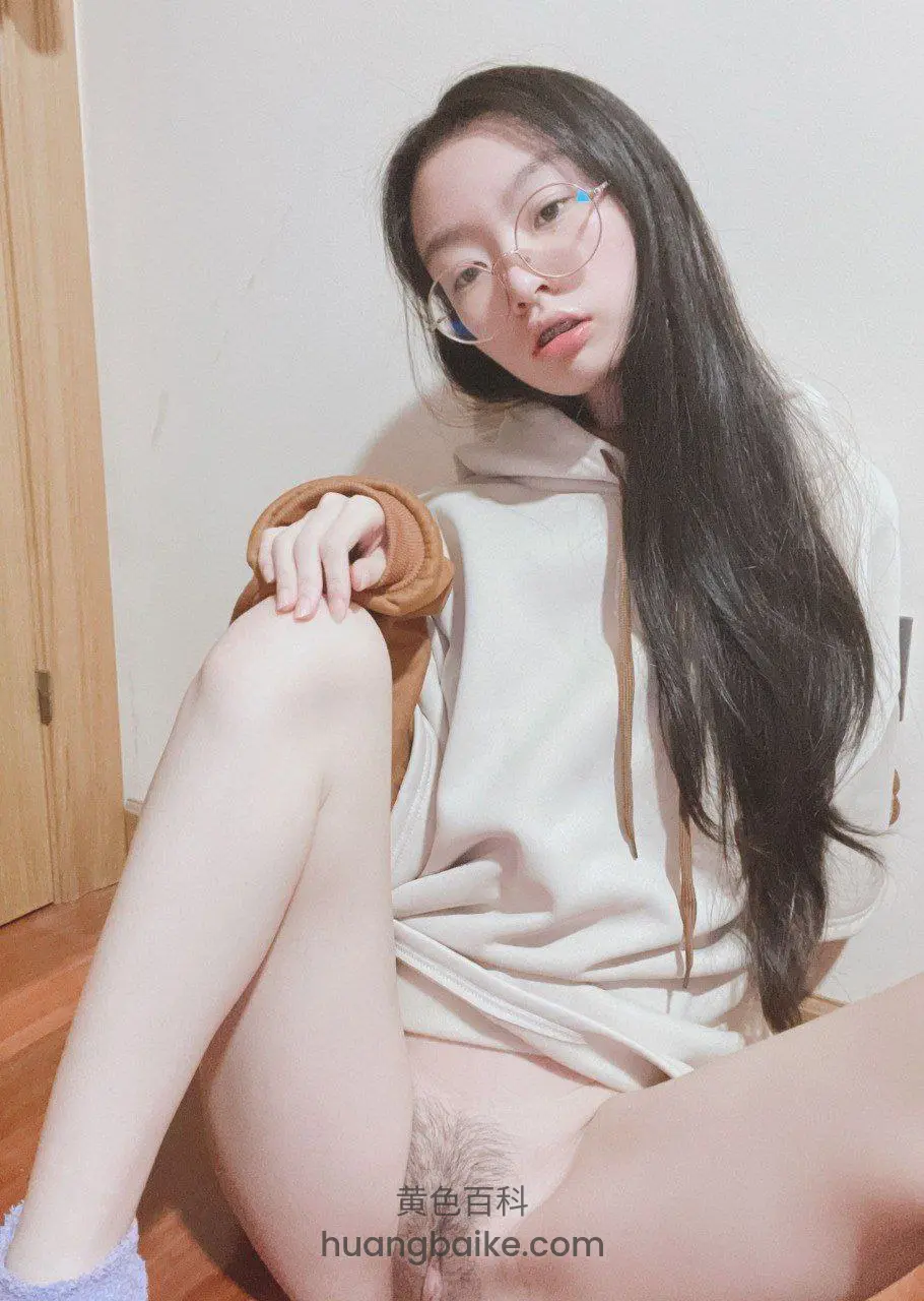 木地板房间里坐着，手搭膝盖