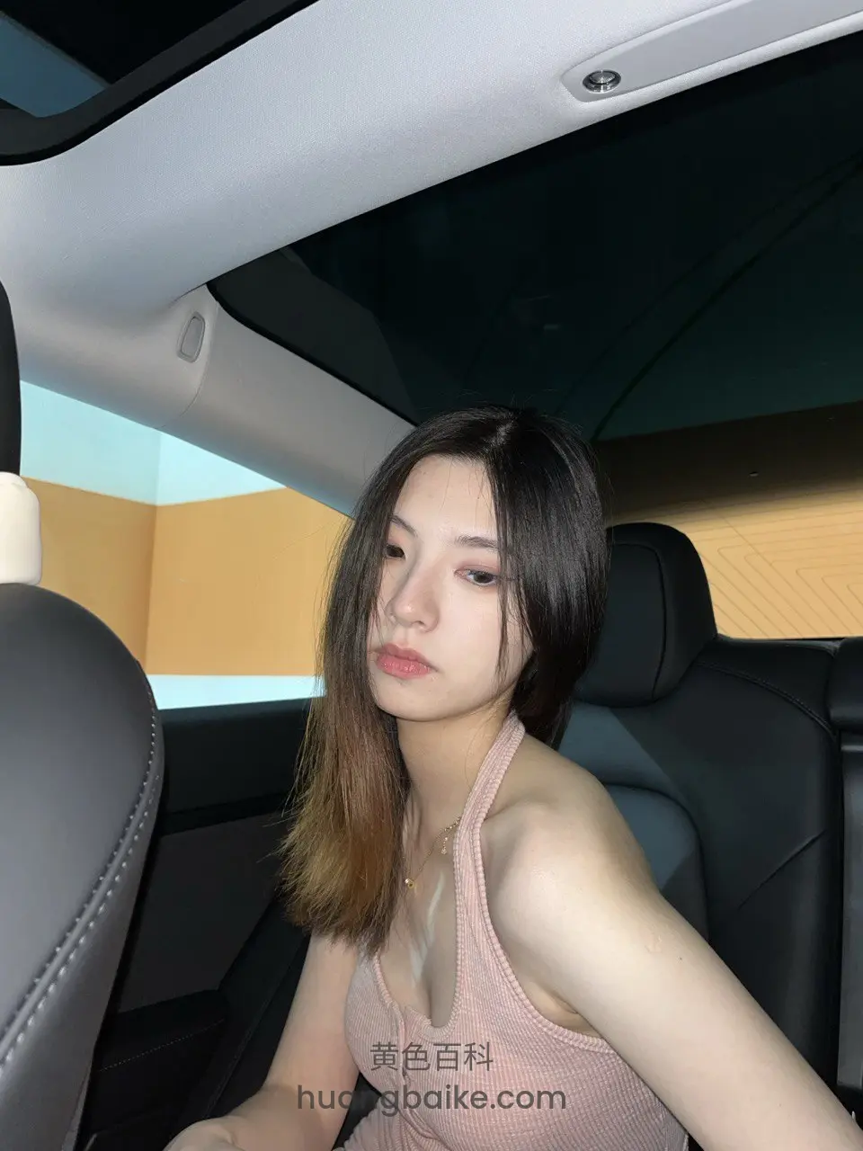 车后座回头看镜头，手搭在腿上