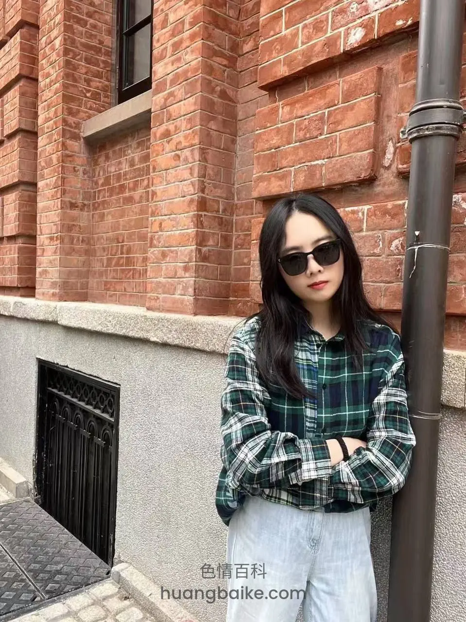 靠砖墙抱臂戴墨镜