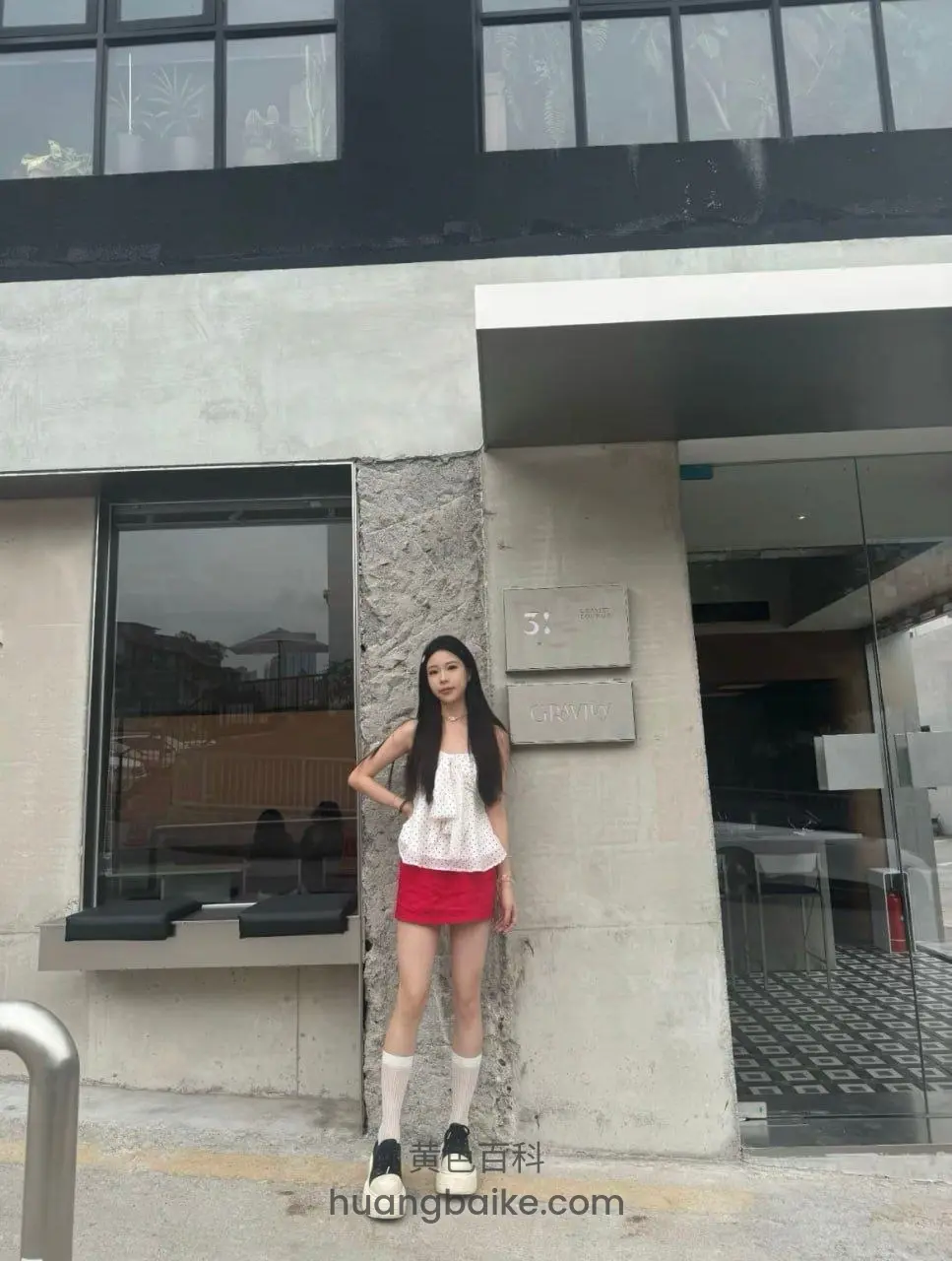 建筑门口站立，手叉腰，身后有31和CULTURE字牌