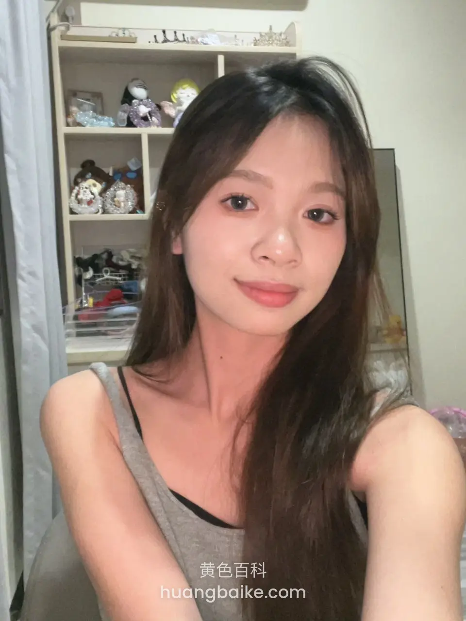 卧室里自拍，身后书架摆满玩偶