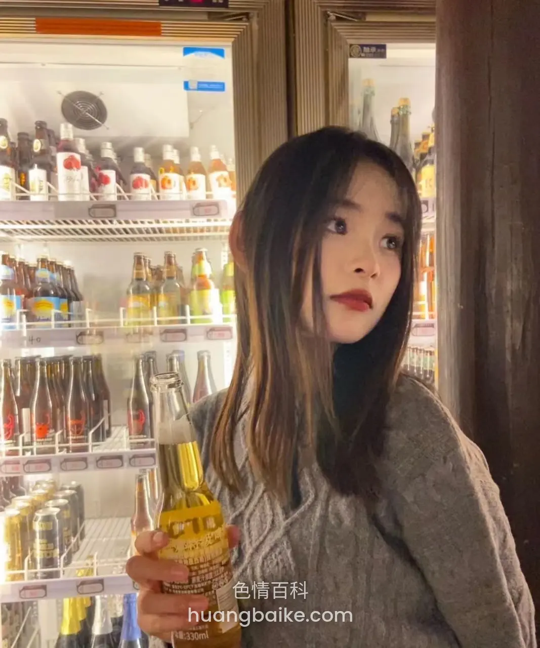 超市冷藏柜前拿着啤酒瓶看镜头