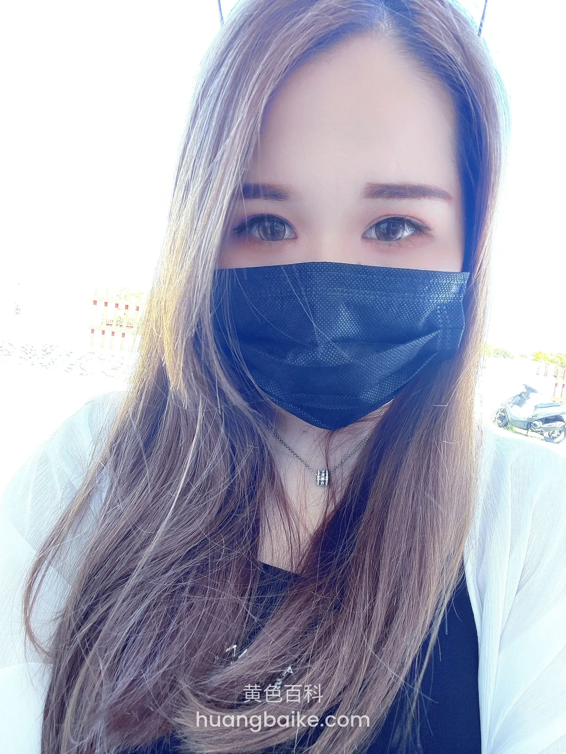 户外戴黑色口罩，身后有摩托