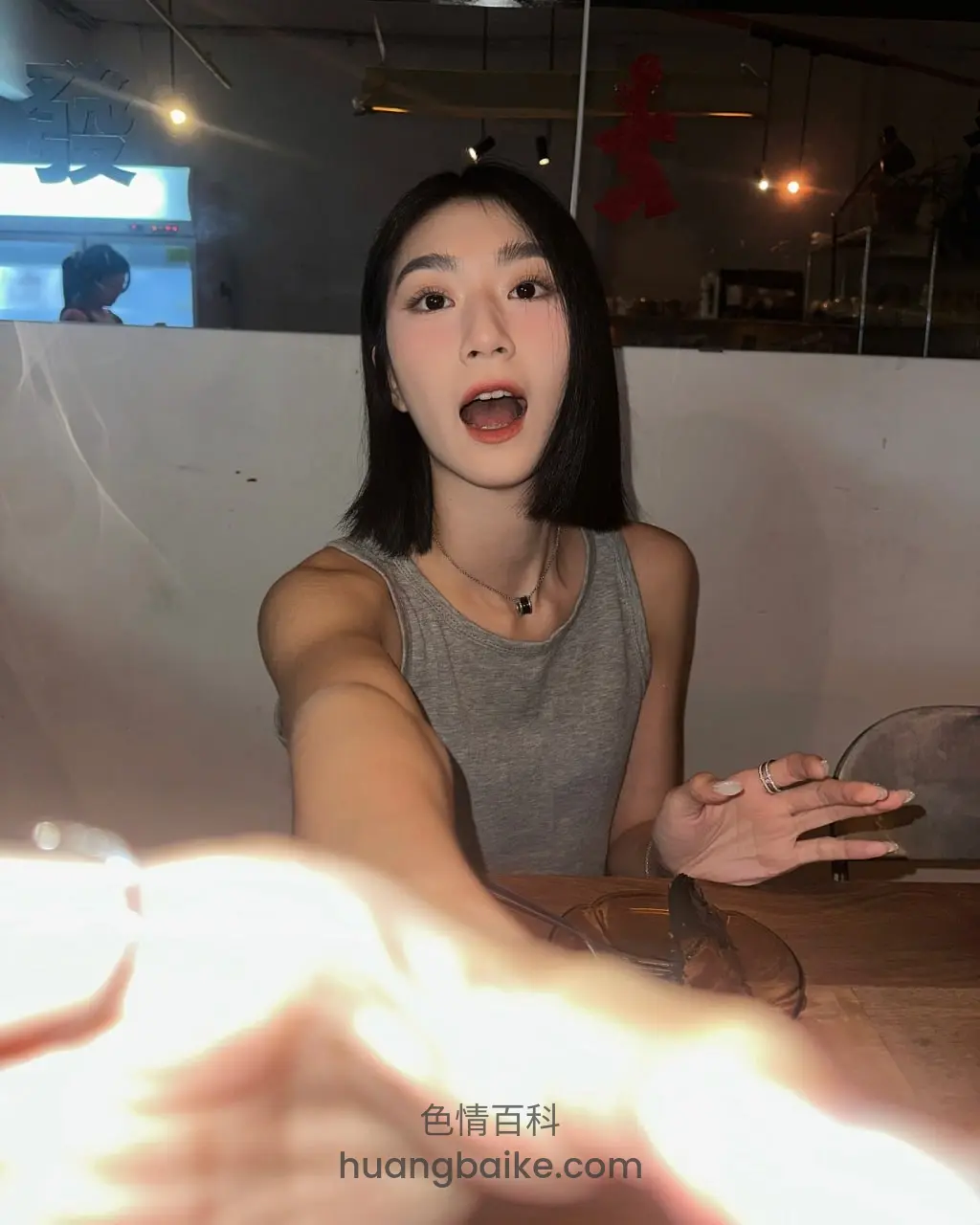 餐厅里对着镜头张嘴说话，手伸向前方