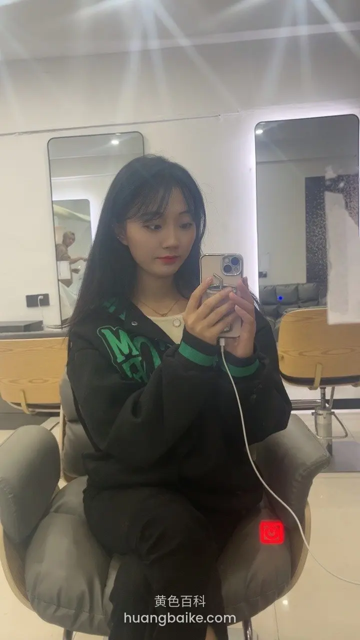 理发店椅子上拿着手机看屏幕
