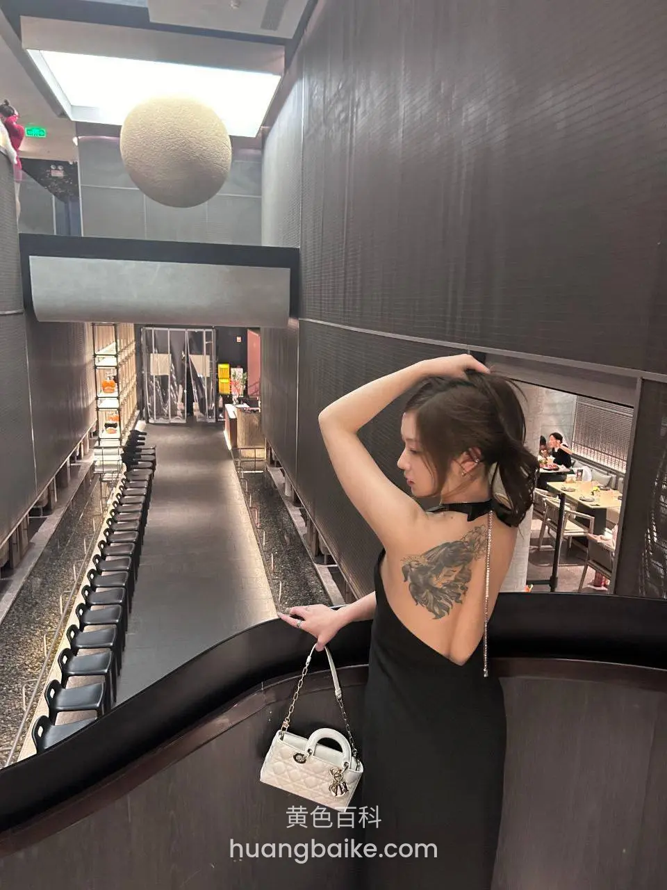 餐厅走廊扶栏，镜头对着后背纹身和包