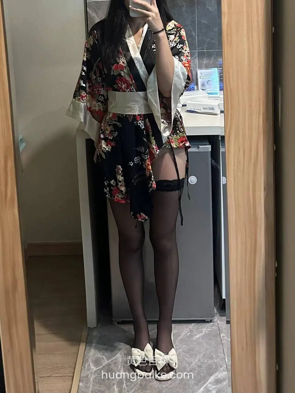门口镜子前站立，手机挡住脸