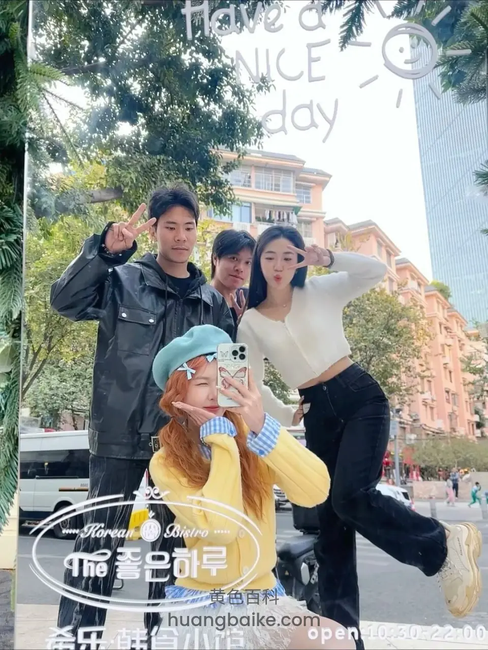 街头镜子前四人比剪刀手，镜头对着手机自拍