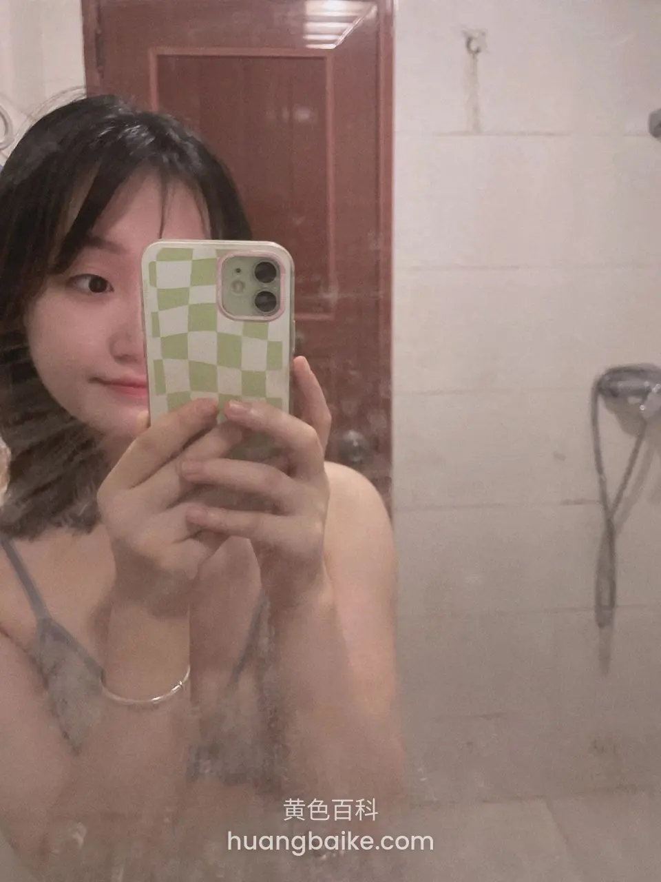 双手握手机拍镜子，绿格子壳