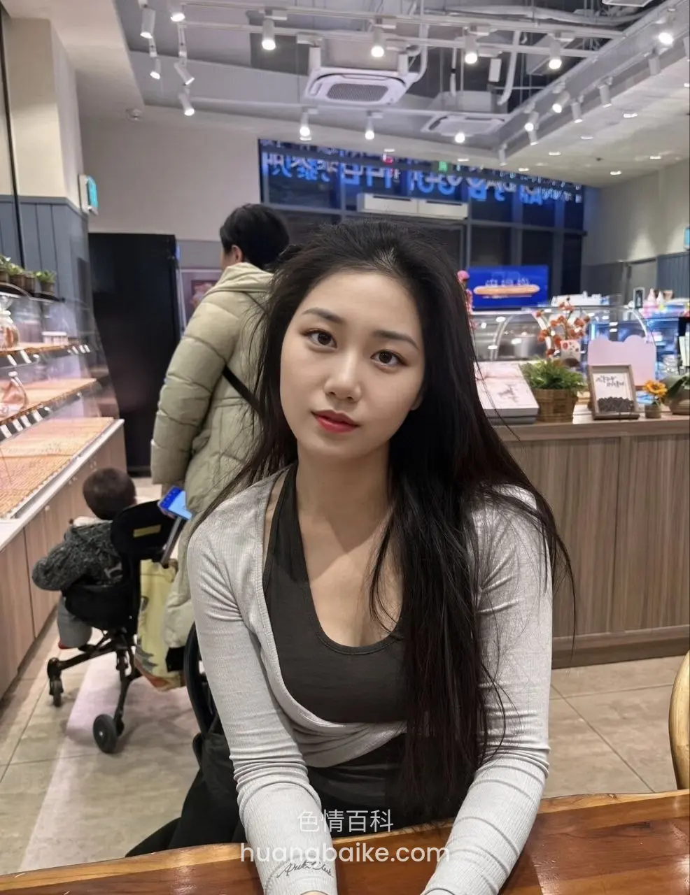 咖啡厅里回头看镜头，身后有人推婴儿车