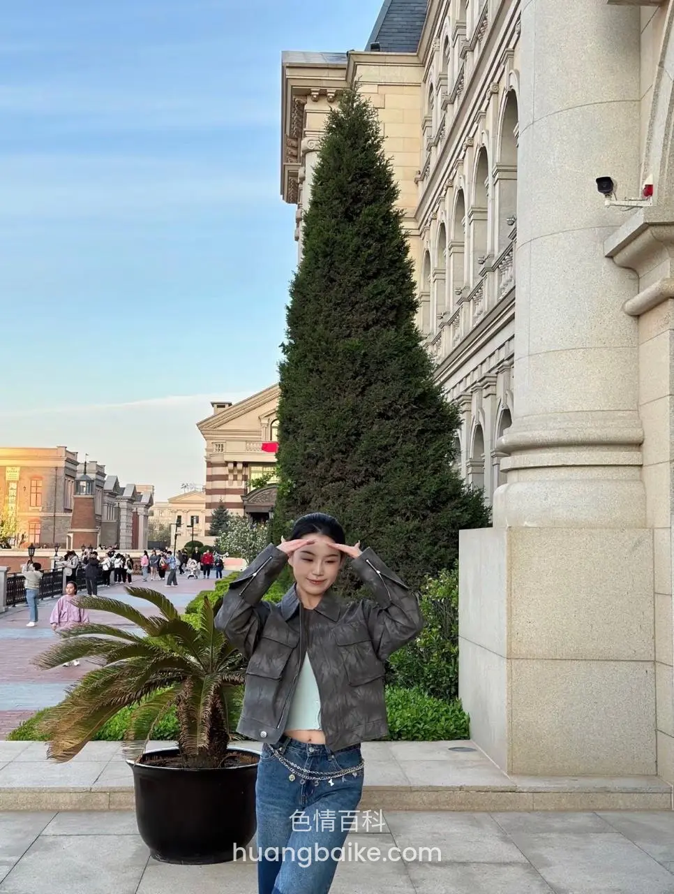 镜头对着路边建筑和树，双手比心