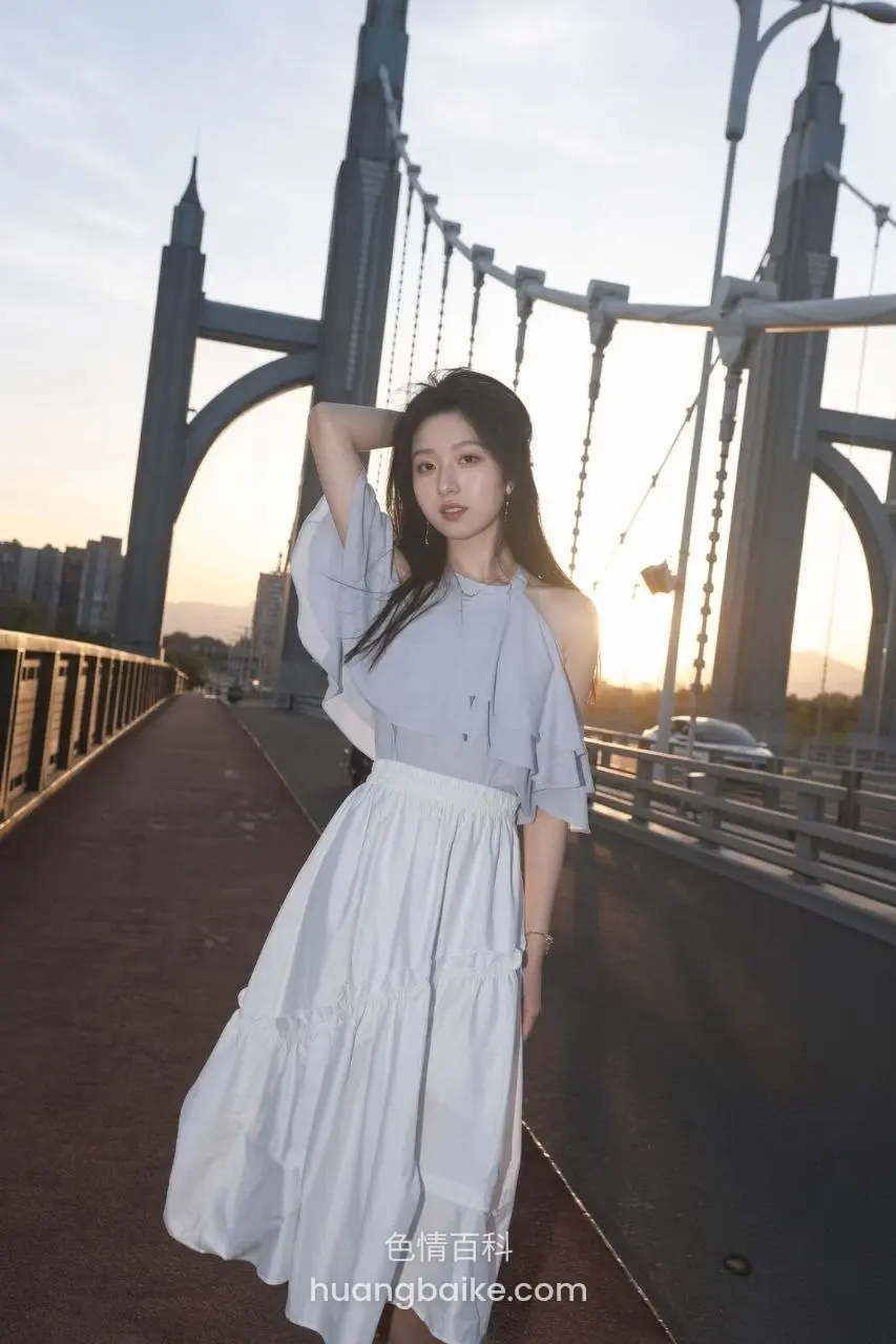 桥上夕阳下站着，手抬到脑后