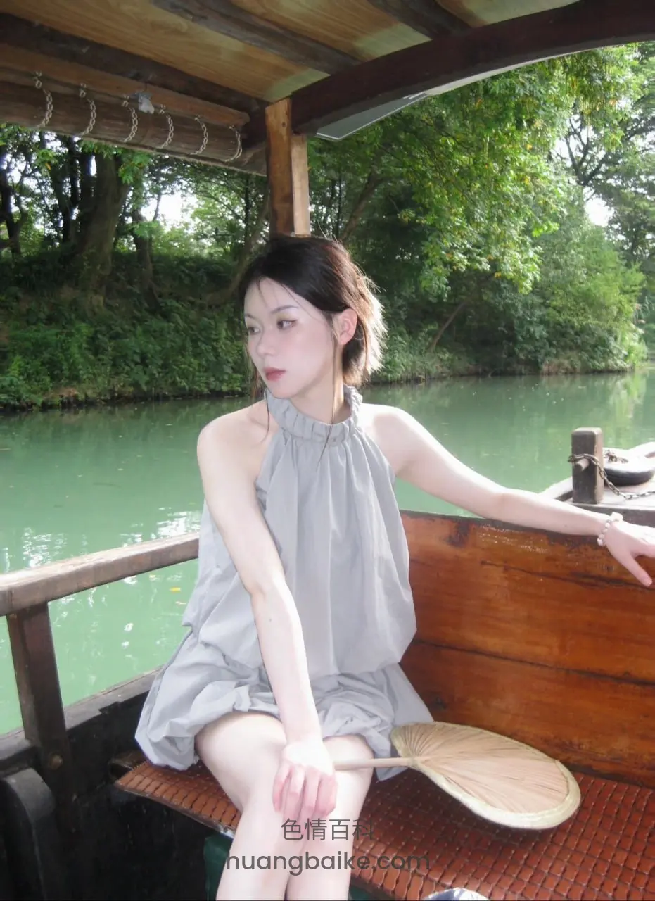 船上拿着蒲扇，河岸绿树成荫