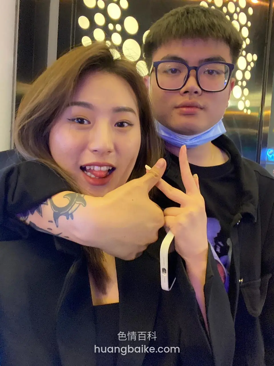搂着男生比耶拍照，舌头伸出做鬼脸