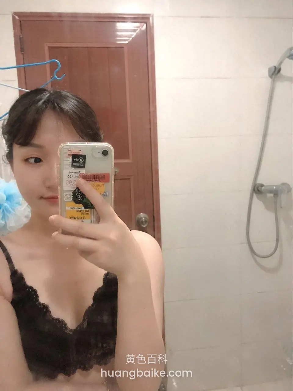 浴室镜子前举手机自拍，手指遮住部分屏幕