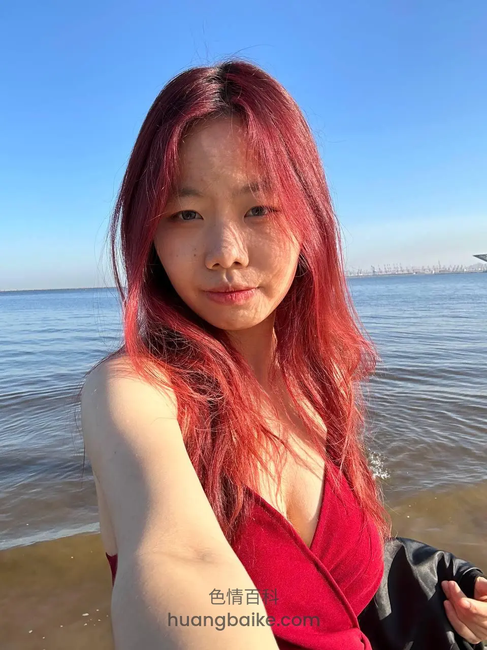 海边自拍红裙，远处有船只