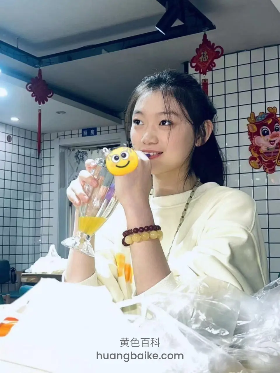 餐厅举着果汁杯，吸管在嘴里