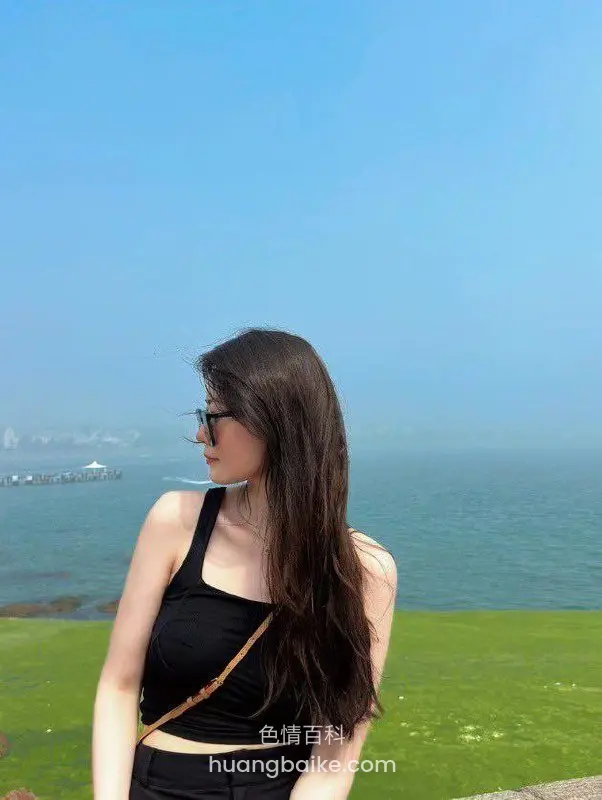 海边草地回头望远方海面和城市