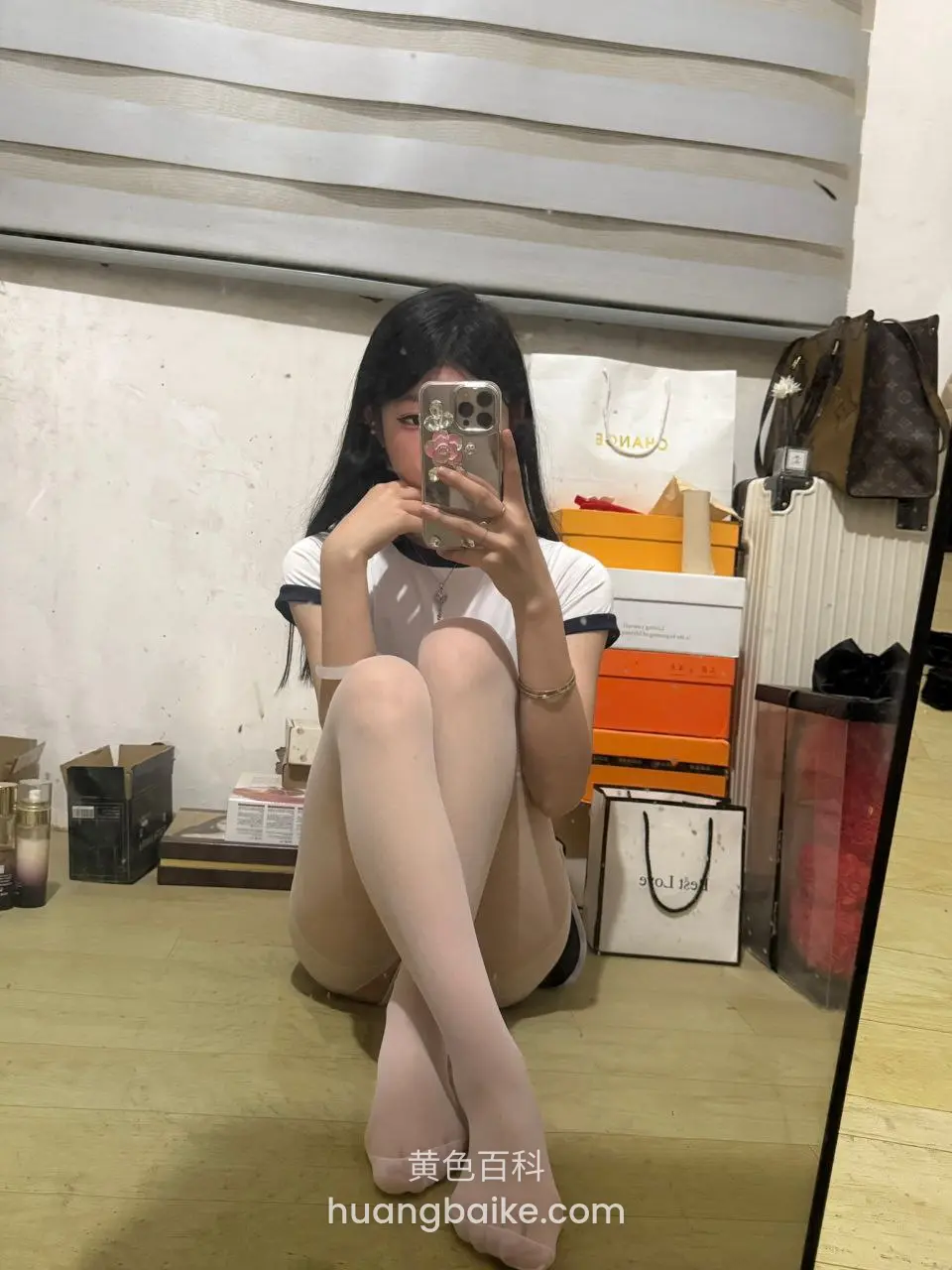 镜子前蹲姿自拍，手机举在脸前