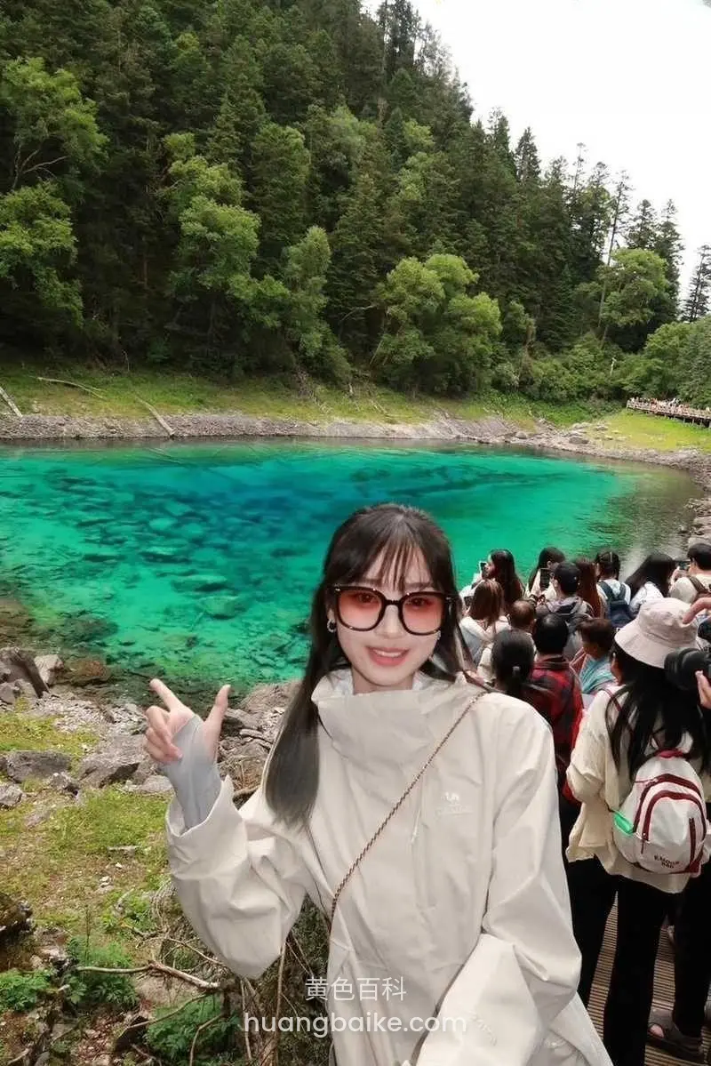 湖边人群中举手比耶，镜头对着碧绿湖水