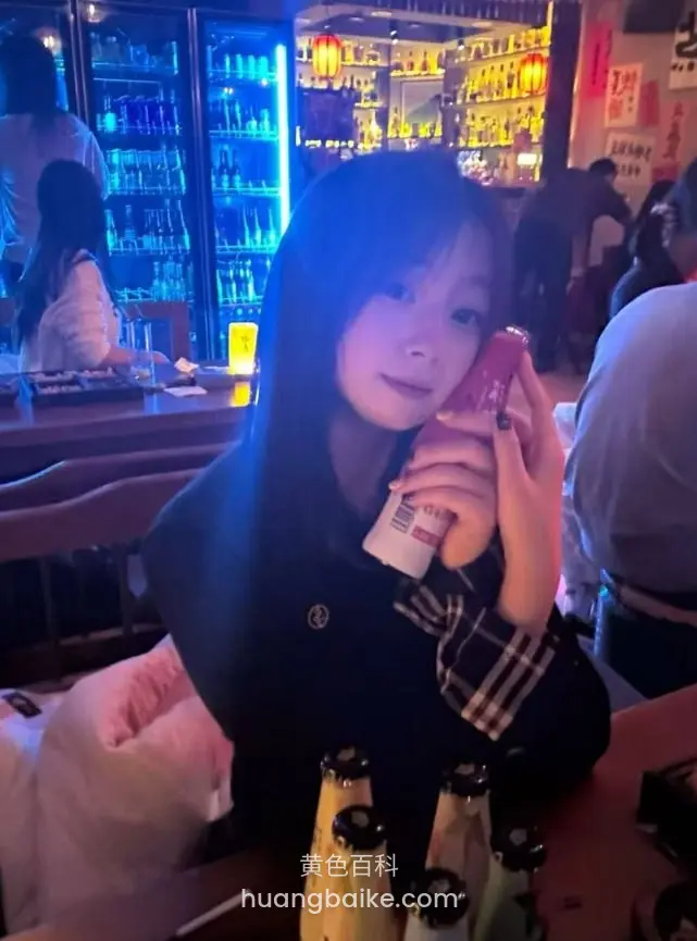 酒吧里双手捧着饮料瓶对镜头看