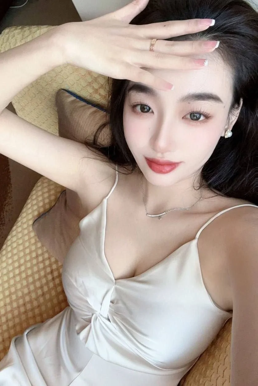 黑长直美女侧躺床上,黄色吊带滑落露出大奶,男友从后面抱住她亲密动作