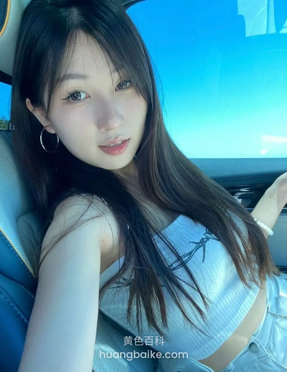 车里自拍看着镜头，手搭在方向盘上
