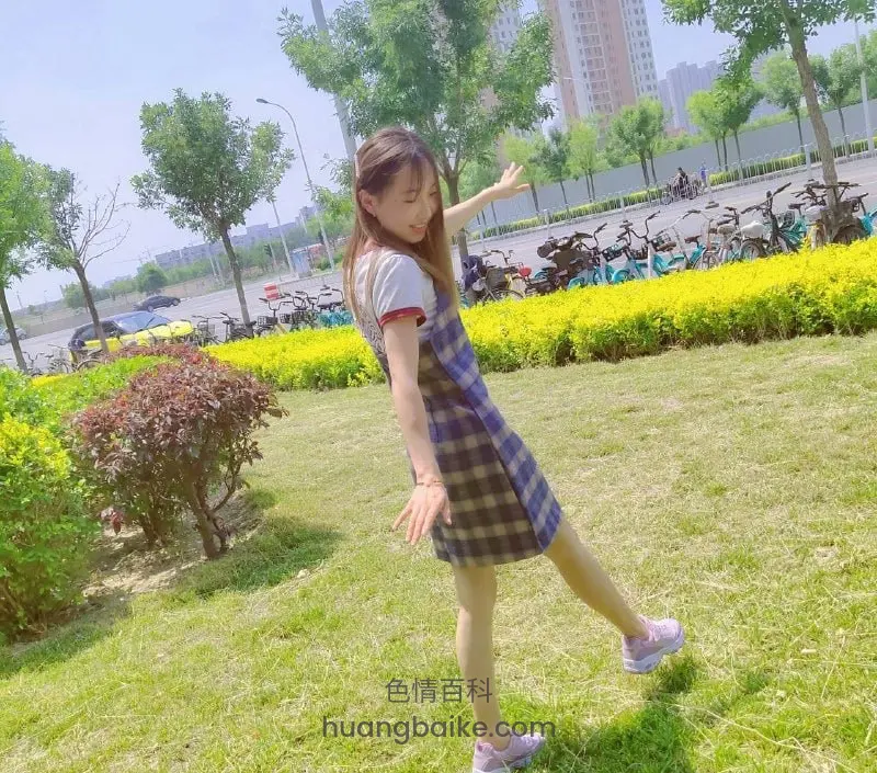 公园草坪上伸腿站立 身后停满共享单车