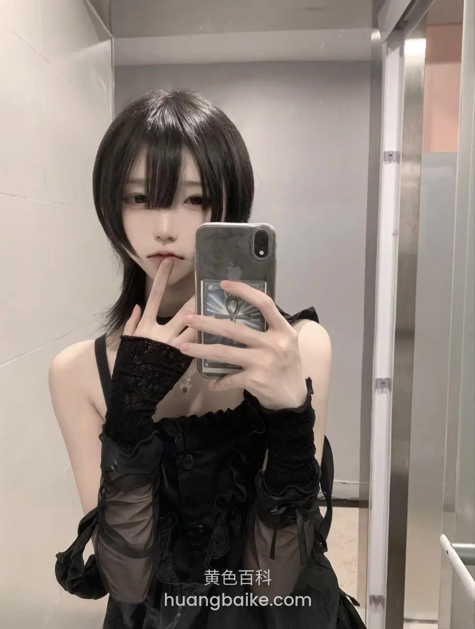 镜子前自拍，手机挡着半张脸，手指比着嘘