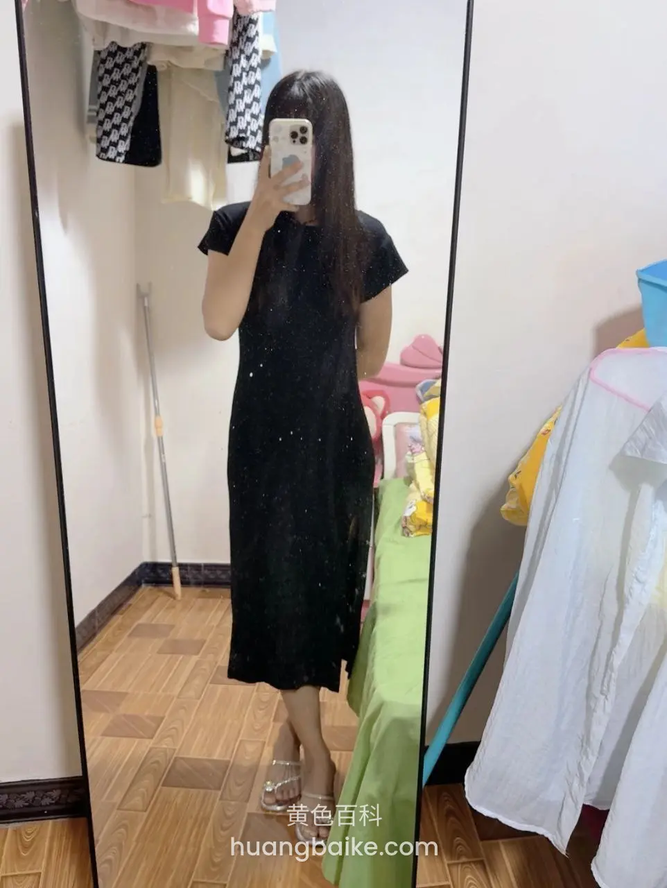 手机举在胸前拍镜子，身后衣物堆
