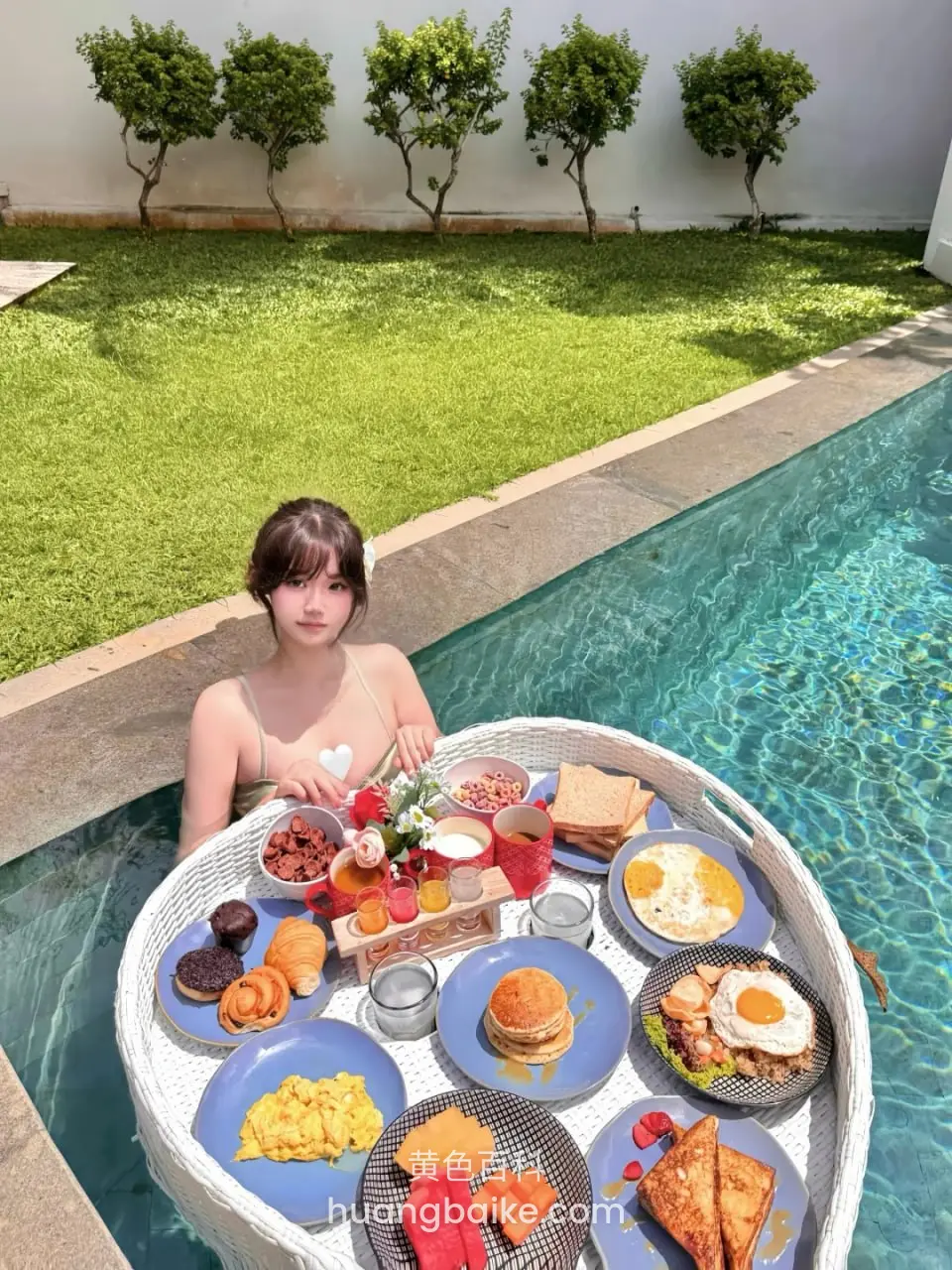 池边浮板早餐上坐着，拿着花看镜头