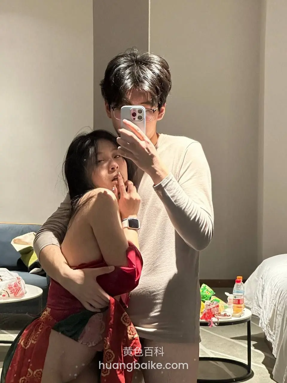 房间里镜头对着手机，男人搂着她
