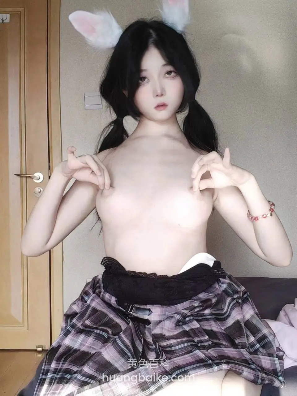 床上拉着兔耳做手势，镜头对着胸口