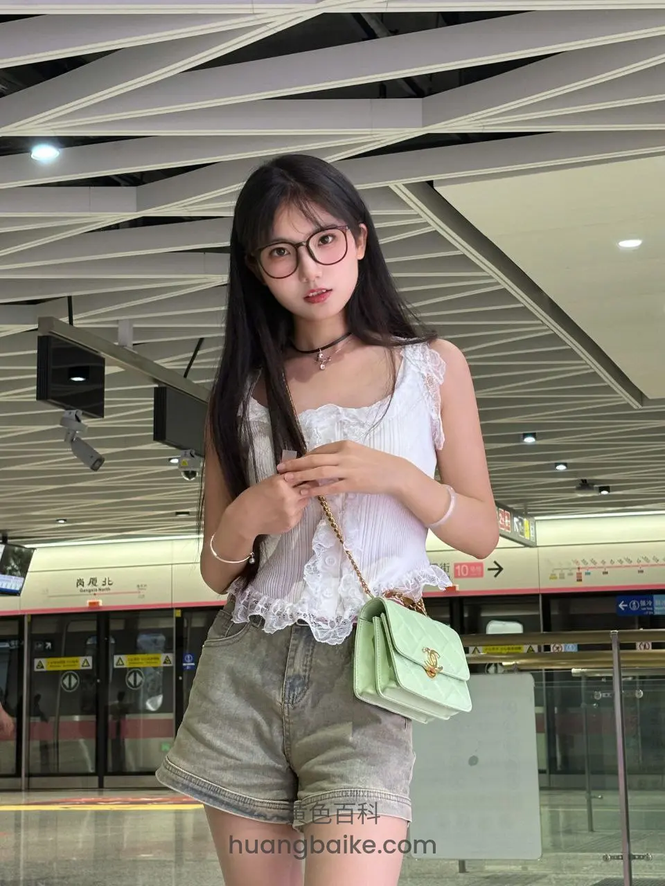 地铁站里拿着手机，身后是列车和站牌