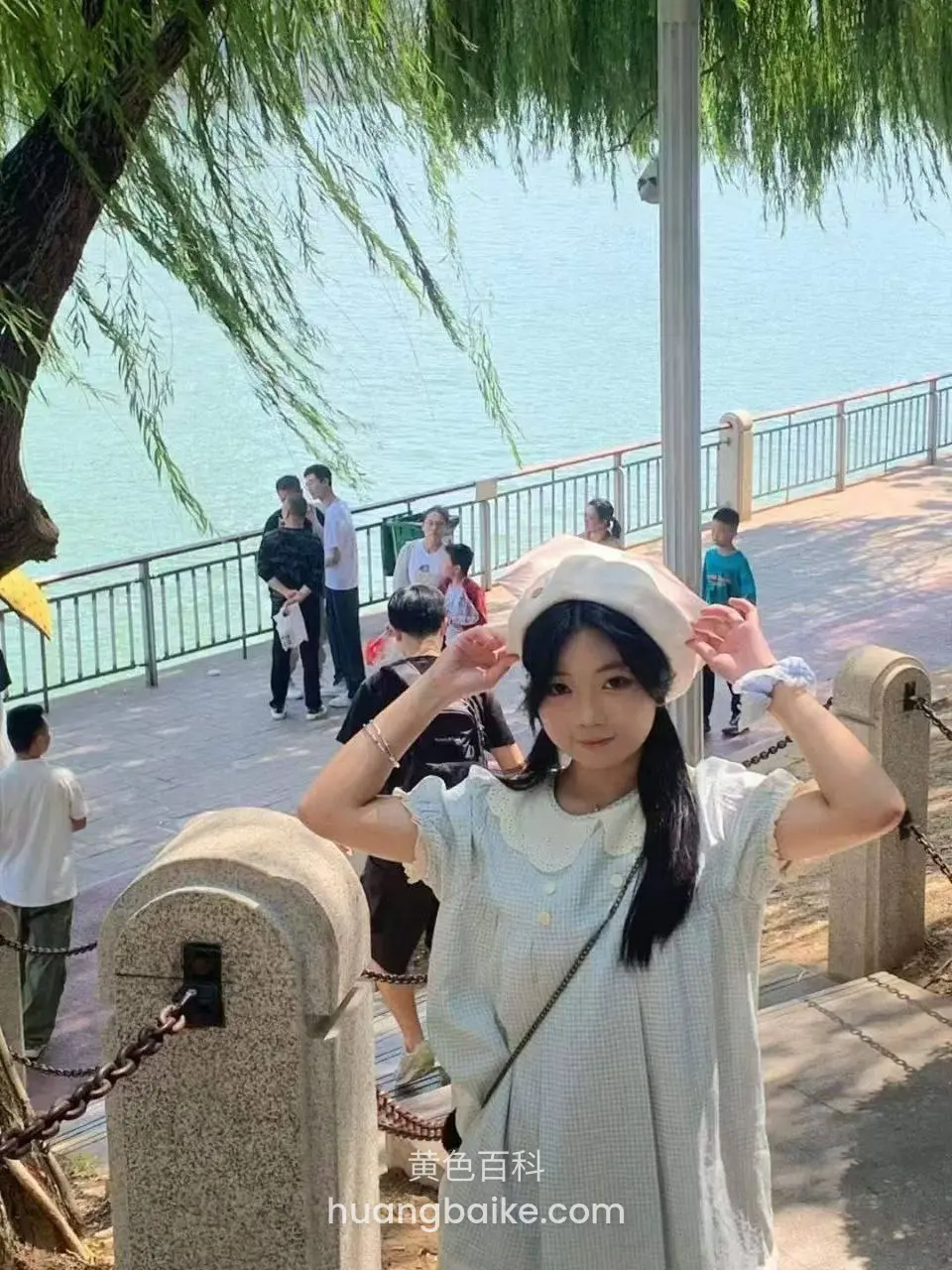 湖边扶着帽子看镜头