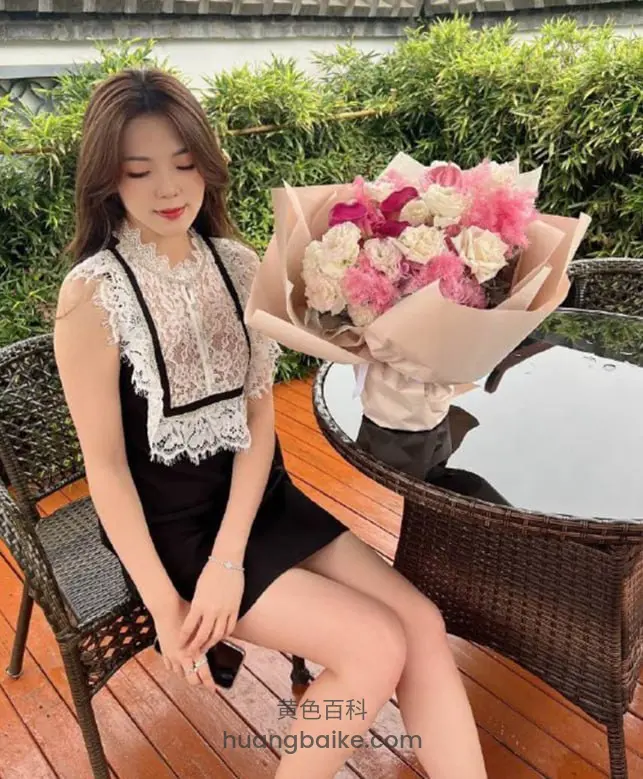 阳台藤椅上坐着，手里拿着手机