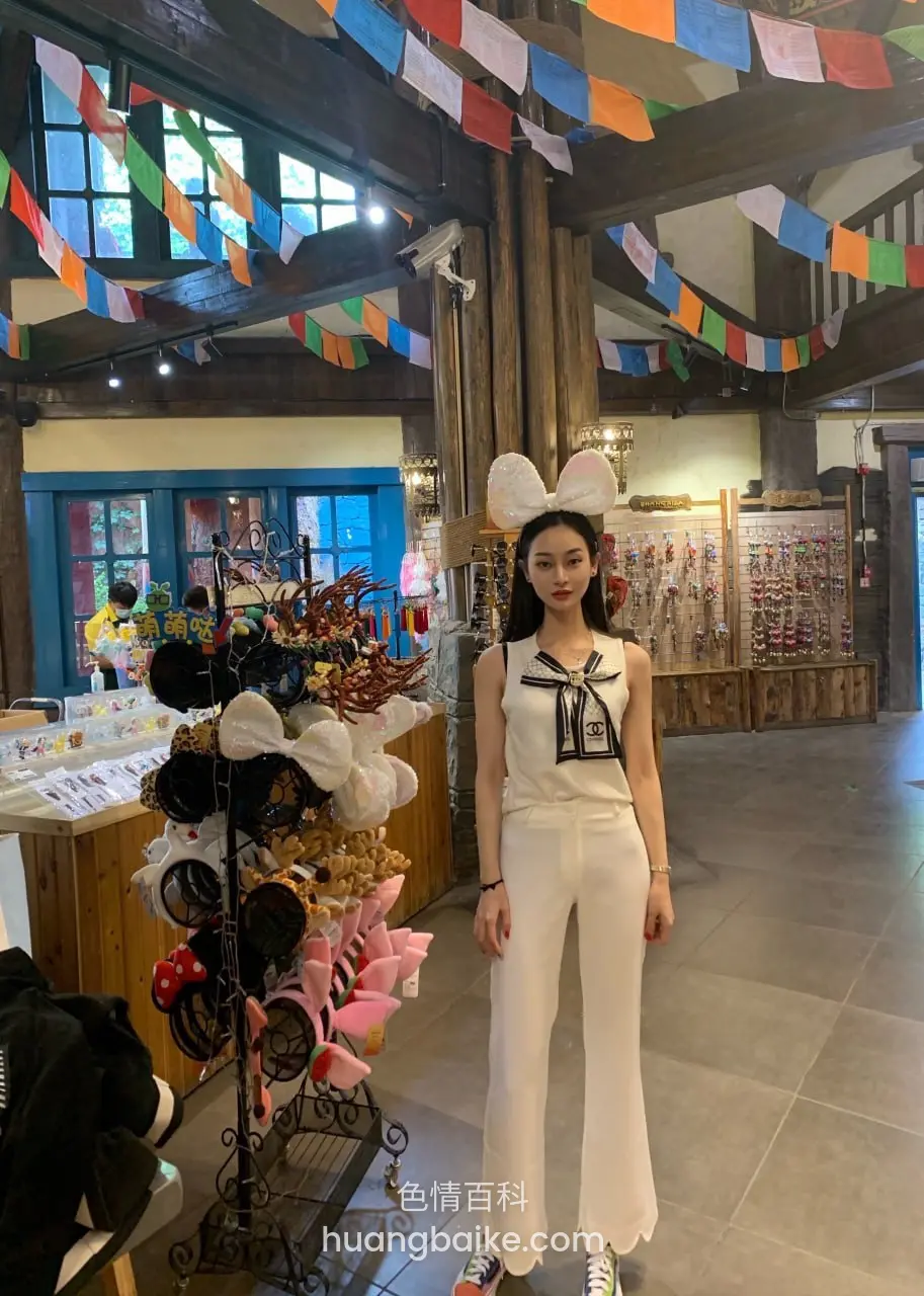 店里彩旗下面站立，旁边帽子货架