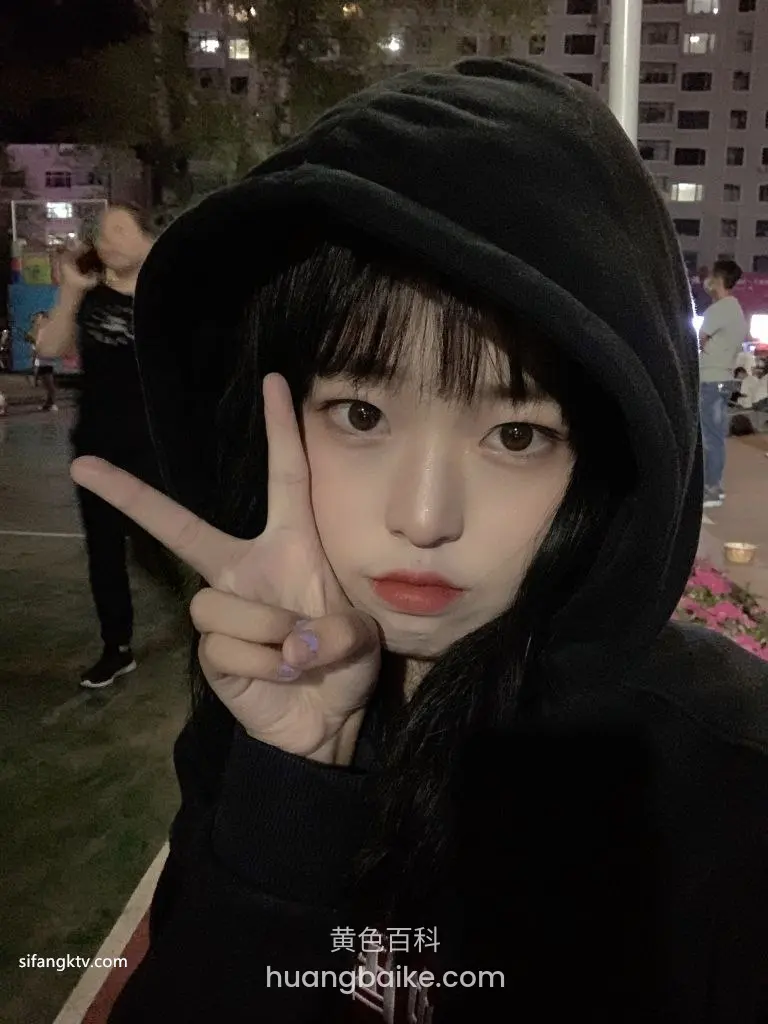 夜间户外比着剪刀手看镜头