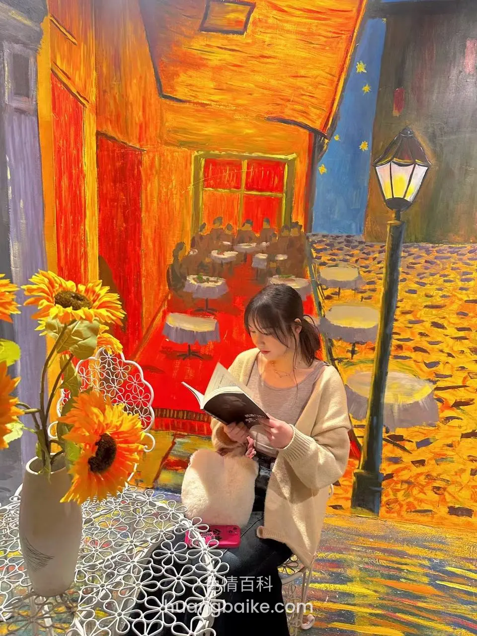 拿着书坐在街头咖啡馆前
