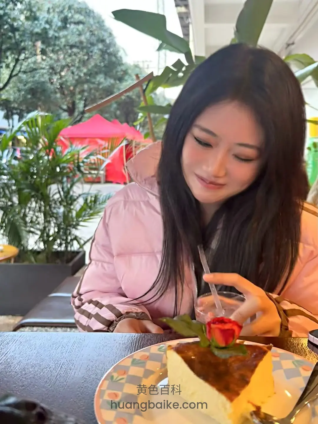 桌前喝饮料，吸管插着玫瑰蛋糕